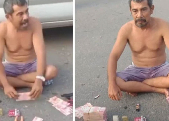 Viral! Pria Pamer Uang Ratusan Juta dengan Santai di Tengah Jalan, Buat Bingung & Ganggu Pengendara Melintas